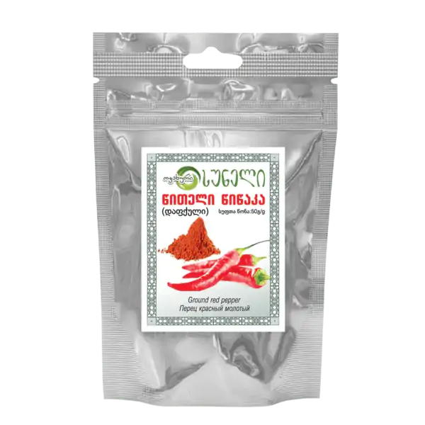 Balenie gruzínskeho mletého červeného korenia v striebornom vrecúšku s potlačou obrázku červených papričiek a mletej papriky na prednej strane.