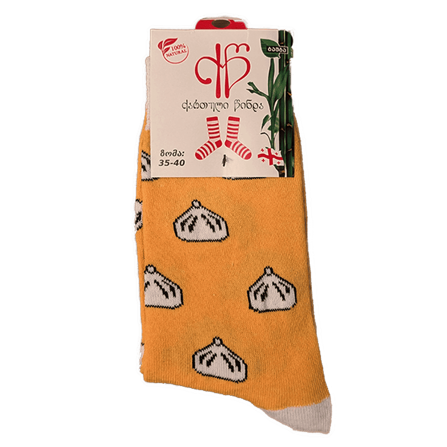 Ponožky gruzínske chinkali žluté (35-40) Žluté ponožky s motívom tradičných gruzínskych chinkali sú štýlovým a pohodlným doplnkom pre každého fanúšika gruzínskej kuchyne. Výrazné, hravé a ideálne aj ako darček. Žlté ponožky s bielymi vzormi khinkali a visačkou s gruzínskym textom, veľkosť 35-40.